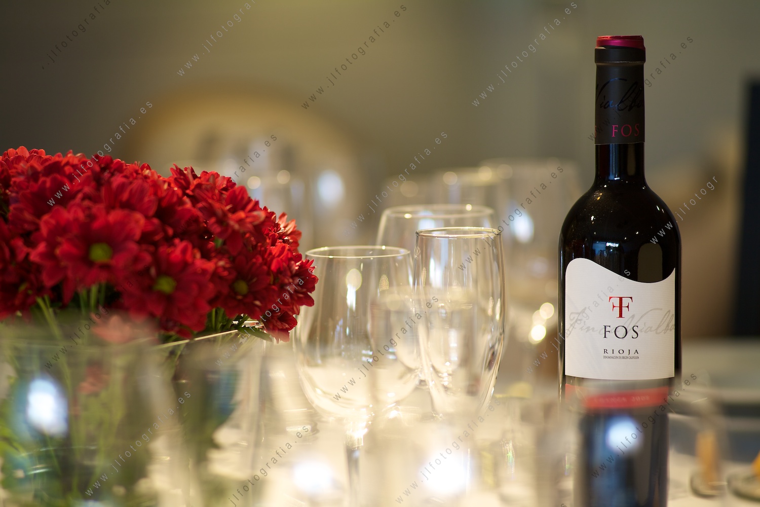 Detalle de la mesa con copas, flores y vino