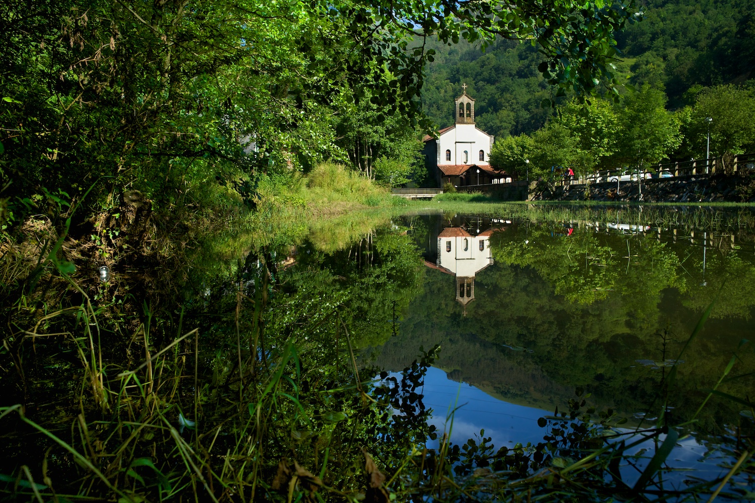 Postal de la iglesia de El Regato con las aguas del río Castaños