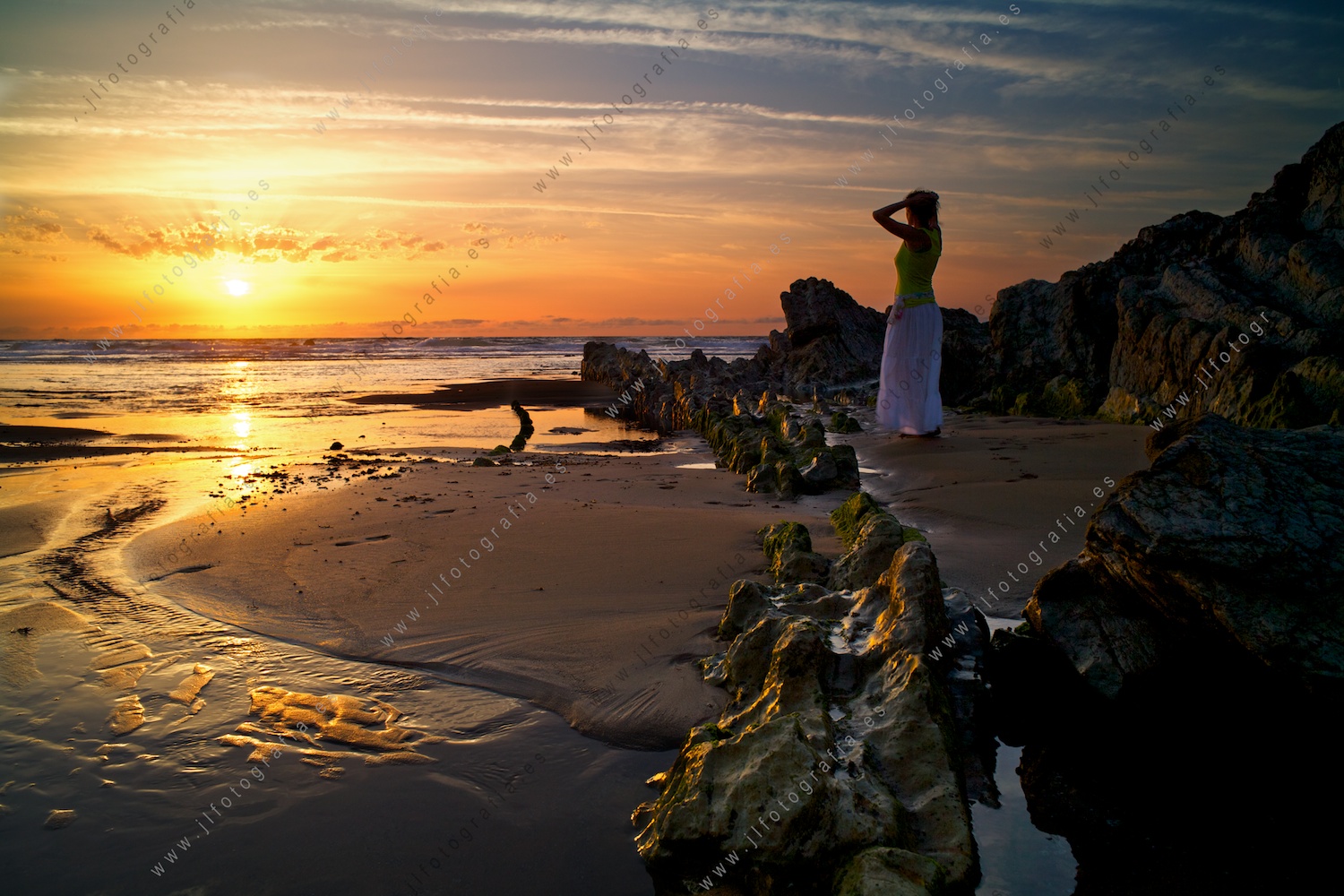 Puesta de sol, señorita y rocas.