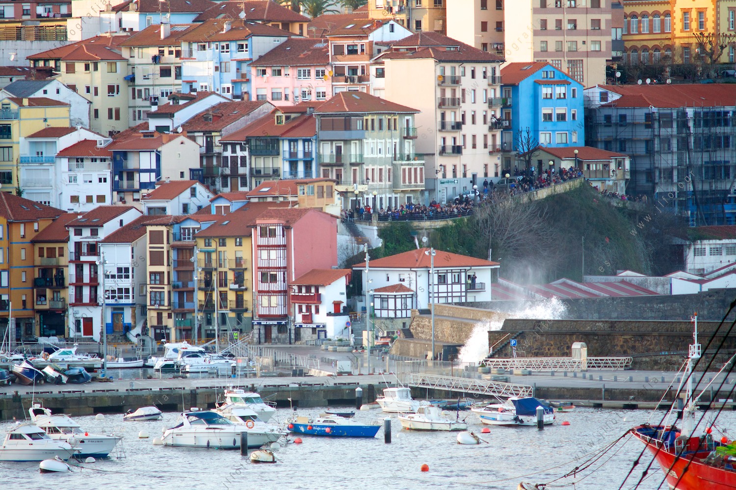 El puerto de Bermeo, cerrado al público, con las olas rompiendo por encima de los diques y reventándolos