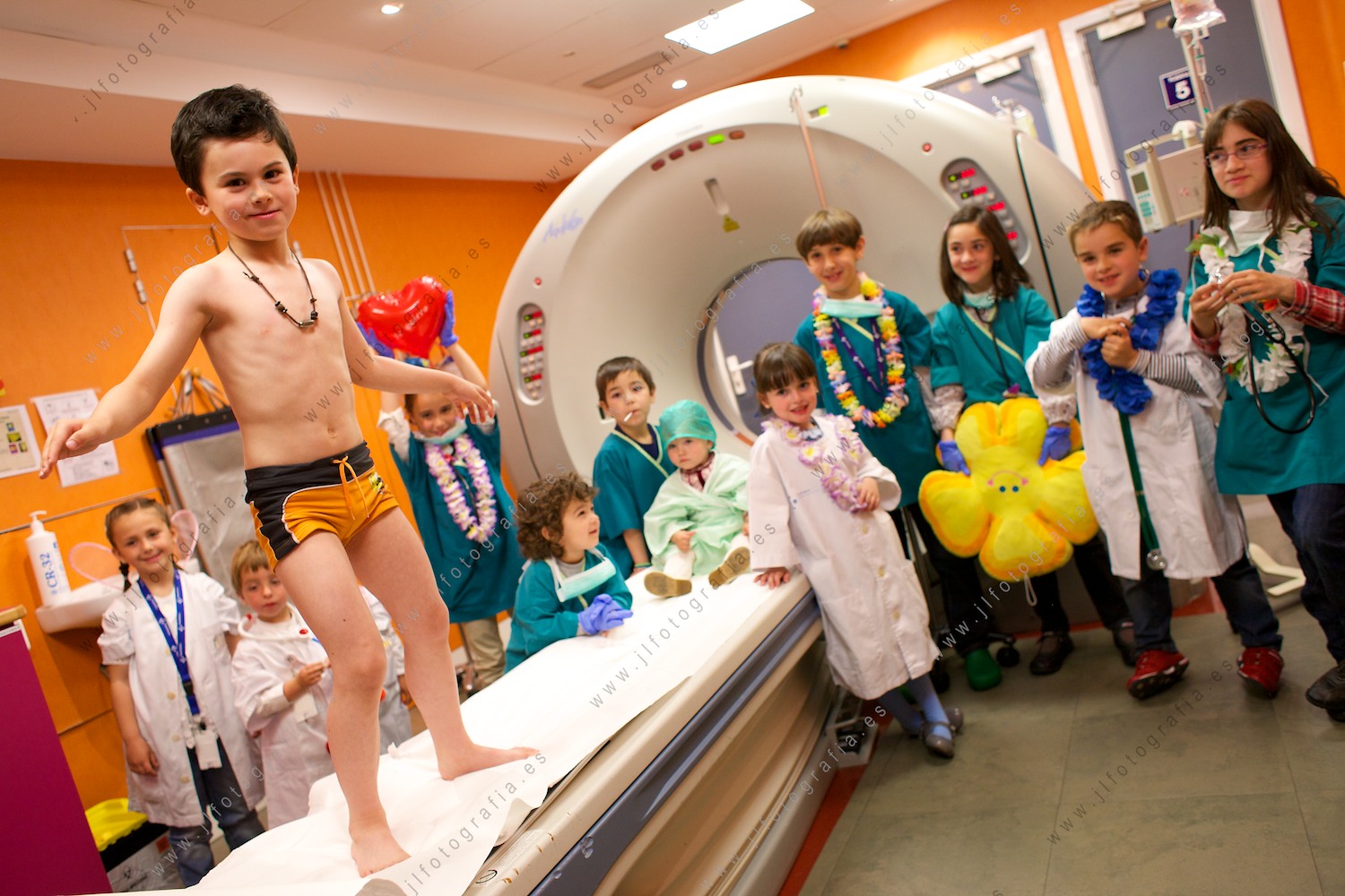 Niños preparados durante el reportaje fotográfico del calendario solidario por la enfermedad de Sanfilippo, en la sala de escáner, posando como un surfista