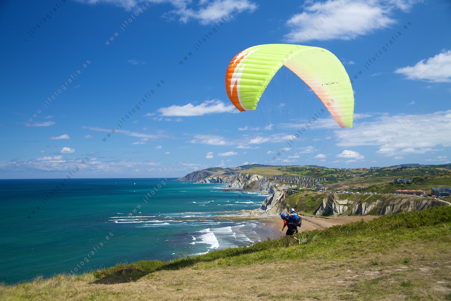 postal de la costa vasca con un parapente despegando de los acantilados de Sopelana