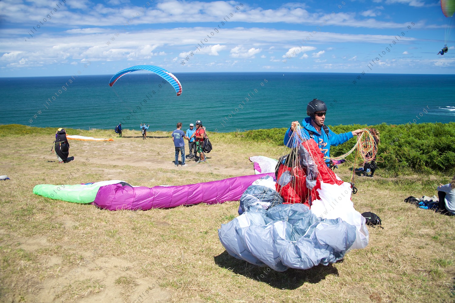 parapentista recogiendo el equipo tras haber volado sobre la costa vasca, en el acantilado de Sopelana