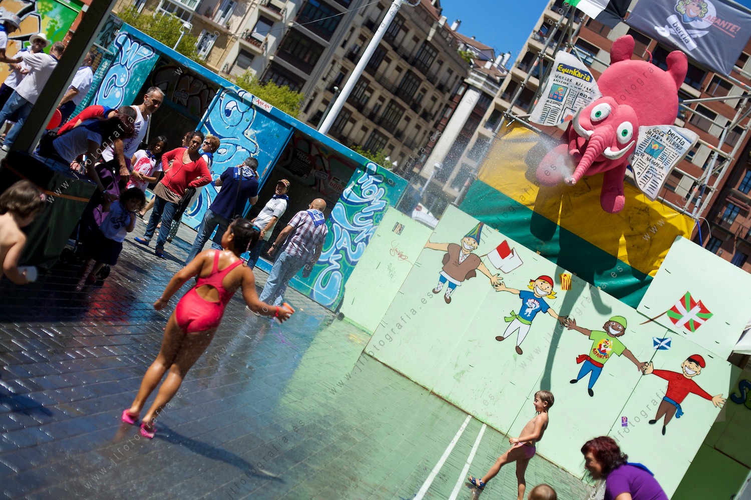 Aste Nagusia de Bilbao, una niña se refresca con el elefante de las txoznas