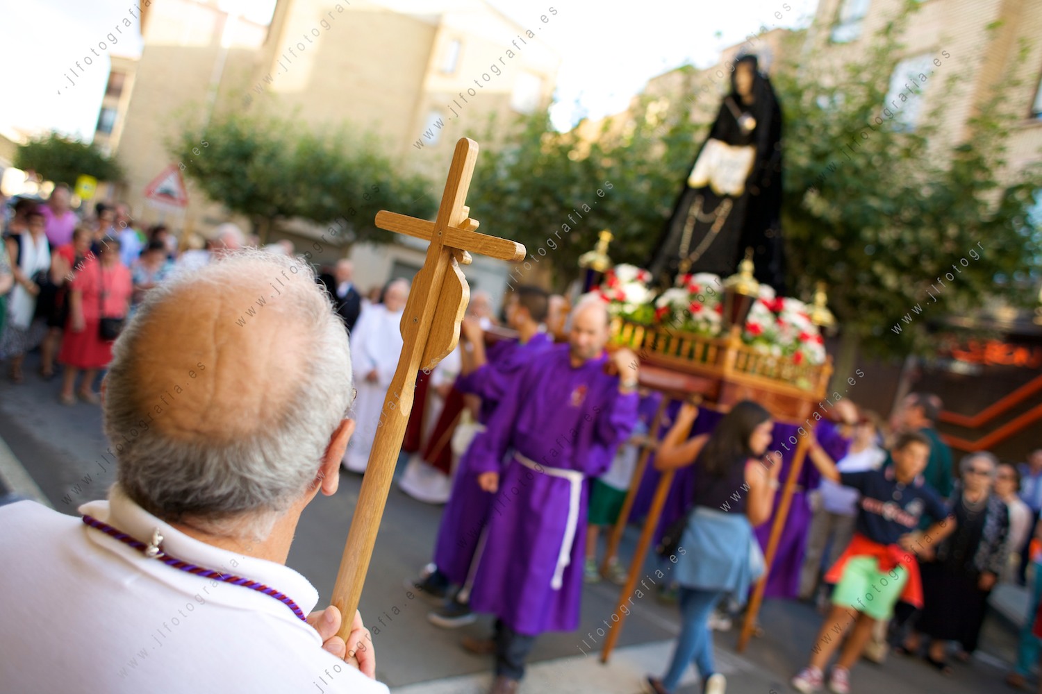 Un señor sujetando un crucifijo en la procesión de los picaos