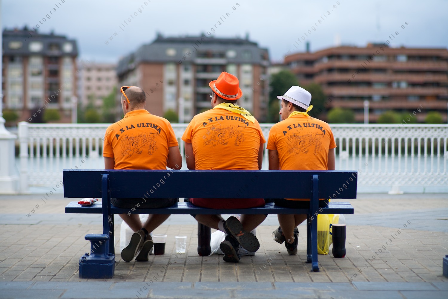 retrato de tres mozos de una cuadrilla en un banco de Portugalete
