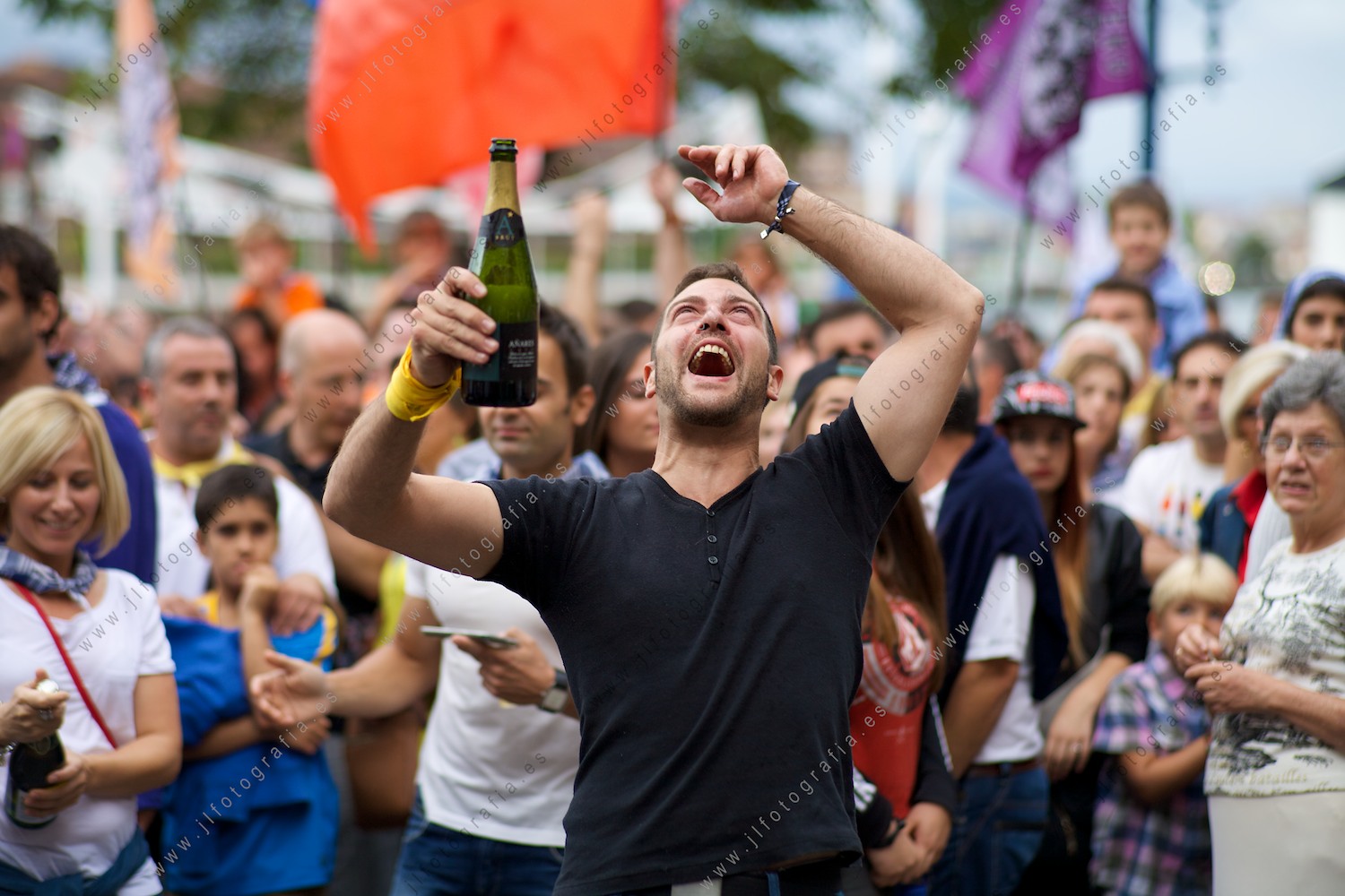 retrato de joven celebrando con una botella de sidra en la mano