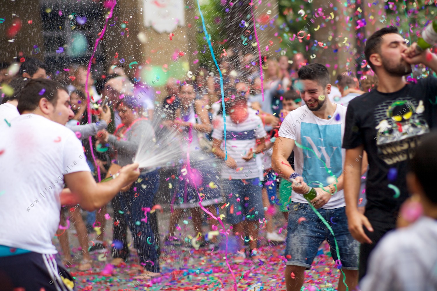 Descorche de botellas, espuma y fiesta de comienzo con confeti en el aire