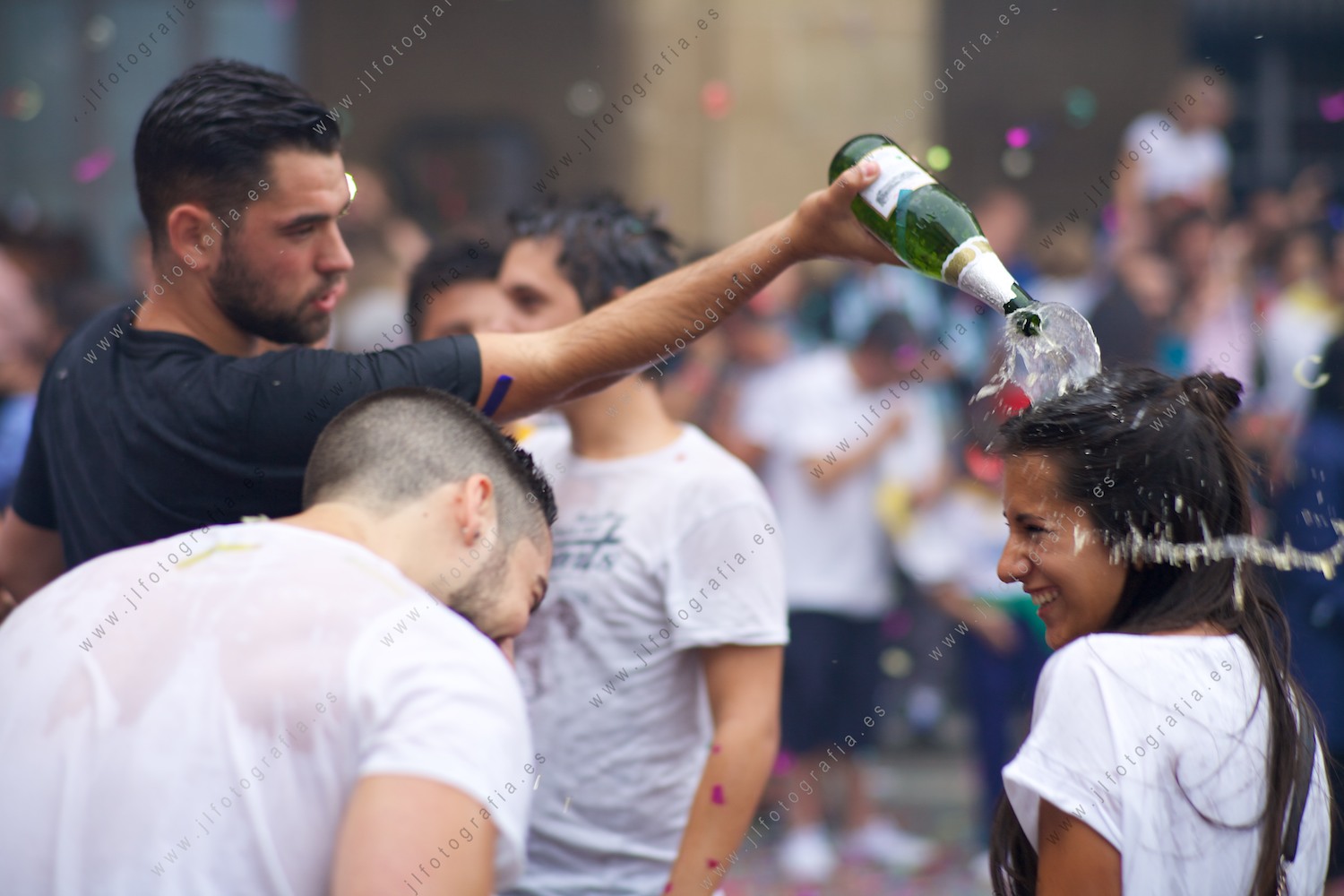 Joven vertiendo sidra sobre la cabeza de una chica en Portugalete