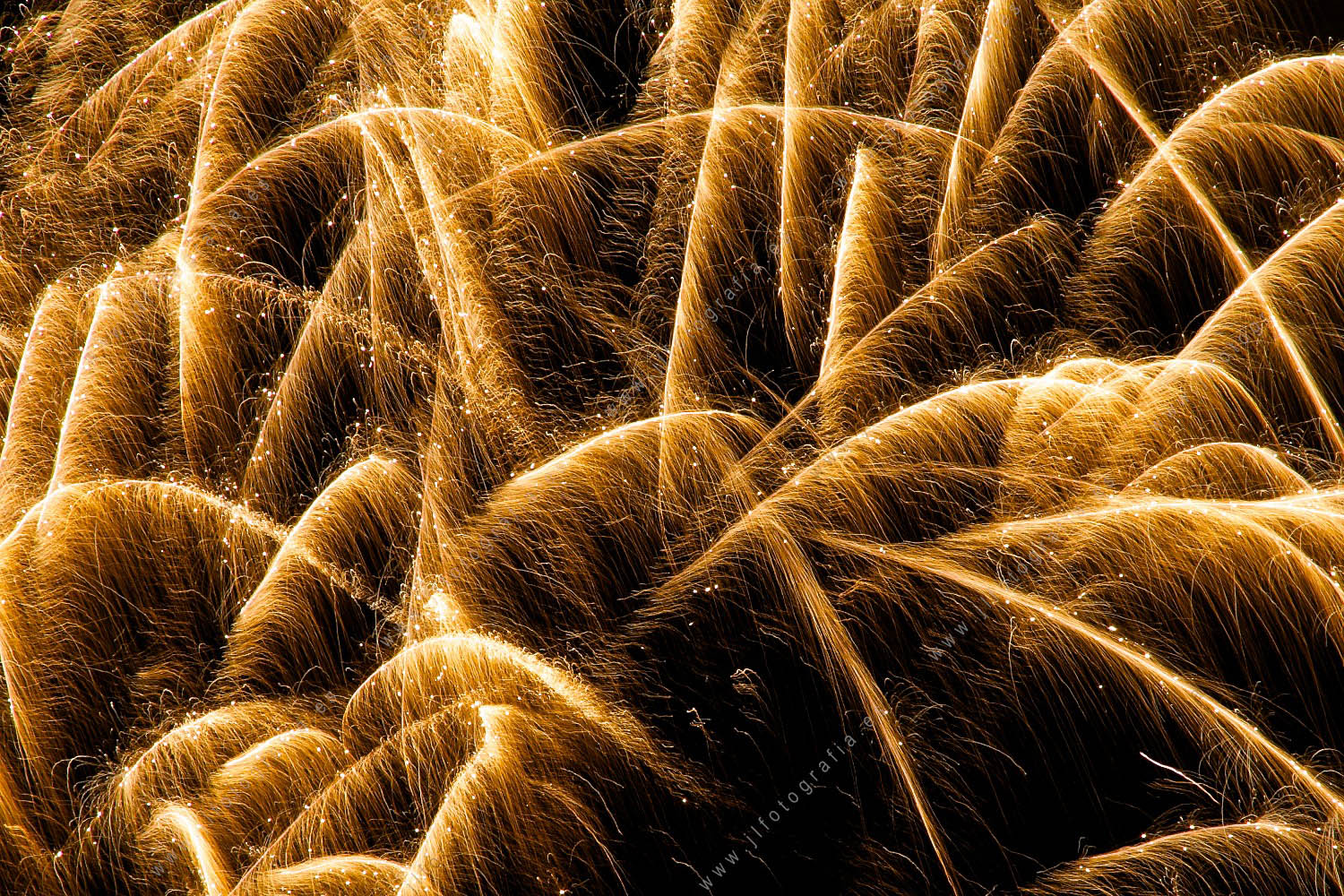 Fotografía de fuegos artificiales de la semana grande de fiestas de Bilbao, detalle de fuegos trama de luz dorada