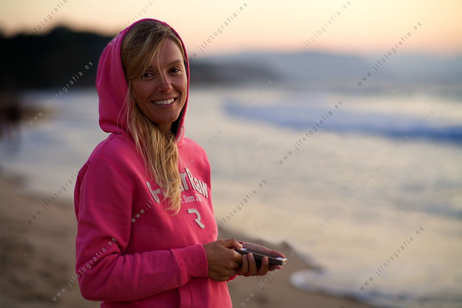 Retrato de plano medio de una preciosa jóven durante la puesta de sol en la costa vasca de Sopelana