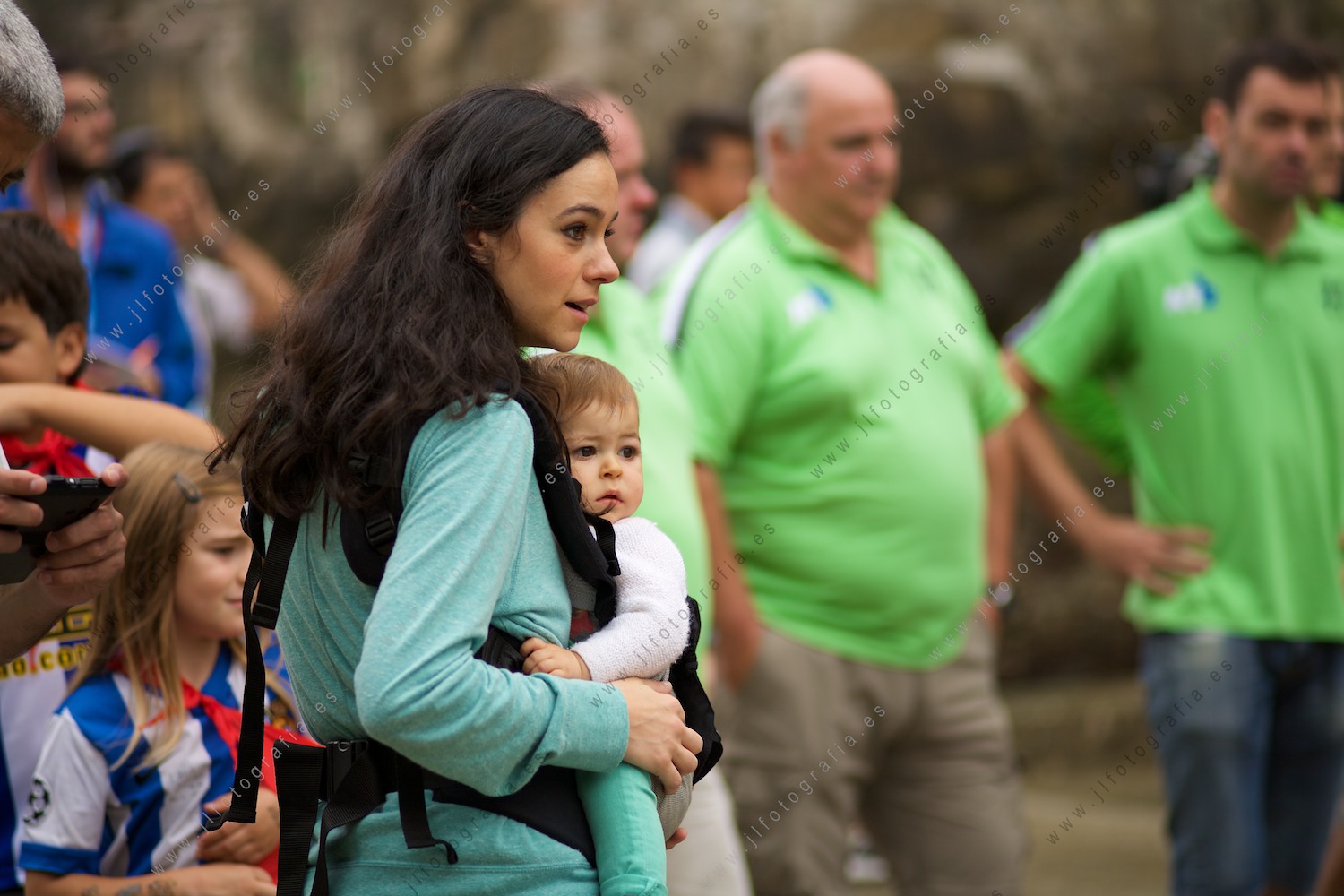 Una madre y su bebe, miran con cariño a uno de los remeros en la disputa de la bandera de la Concha de Donostia, antes de salir en el embarcadero