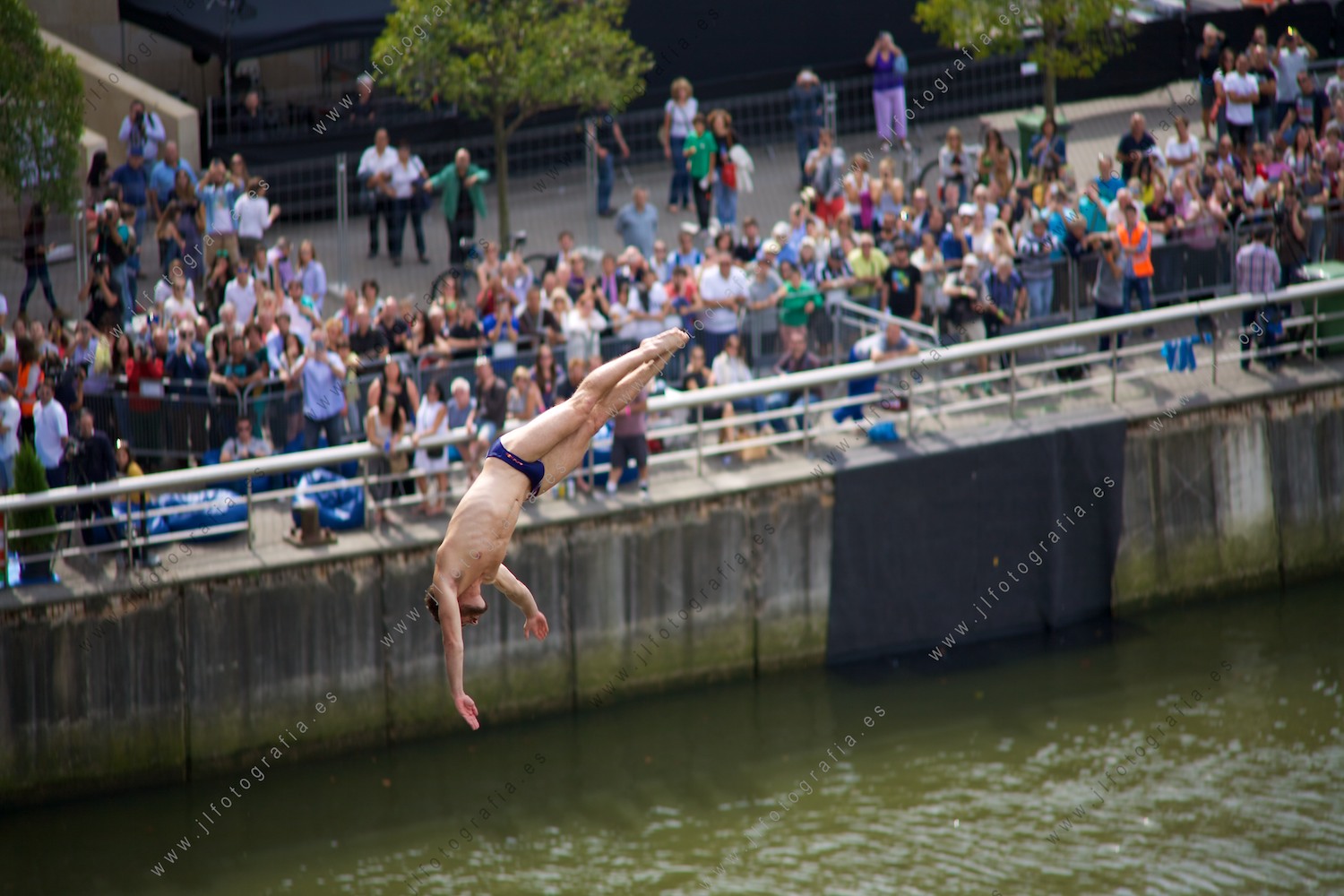 Saltador clavadista durante la competición en el Red Bull Cliff Diving en Bilbao, encarando la entrada al agua