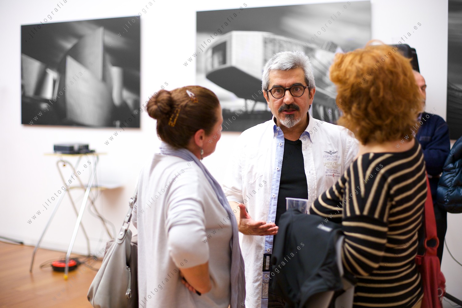 Agustín Sagasti, fotógrafo profesional en su exposición AKT, charlando con amigos.