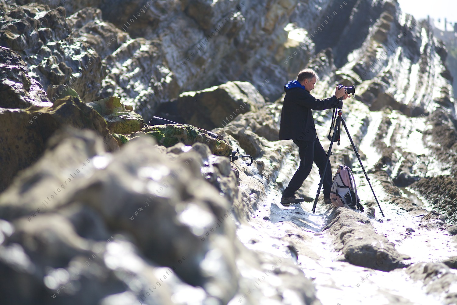 Un fotógrafo de Denbora, haciendo fotos desde un flich de la playa del Porto en Liencres.