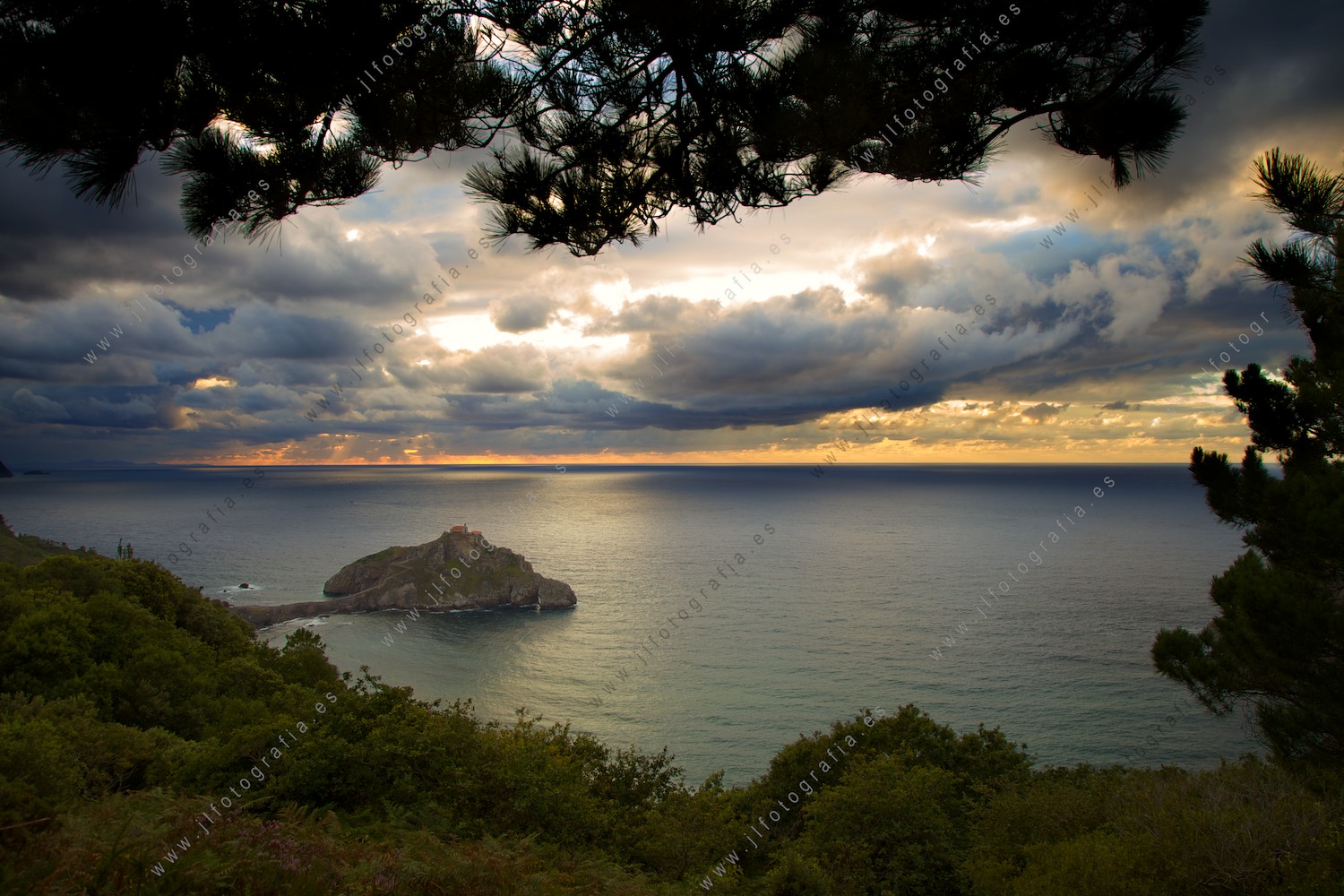 Puesta de sol en un día nuboso de la ermita de San Juan de Gaztelugatxe en Bakio.