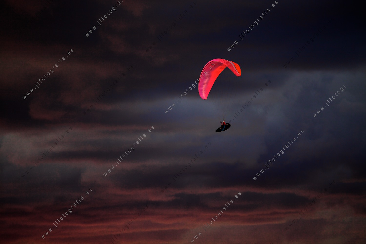 Un parapente en la puesta de sol en el cielo de Sopelana.