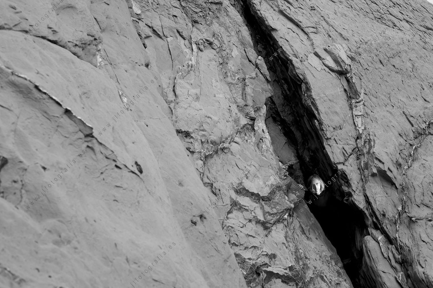 Retrato de una mujer oculta entre las rocas de la playa de La Muriola en Barrika.